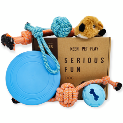 A collection of dog toys including a plush toy, three rope toys, a frisbee, and a treat ball. The toys are designed to relieve boredom and provide entertainment for dogs. This dog toy box is a perfect birthday gift for dog lovers and their furry friends. The toys are brightly colored and made from high-quality materials to ensure durability and long-lasting fun.